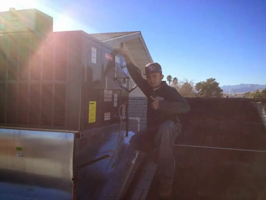 HVAC technician performing Air Duct Cleaning on a rooftop unit in Deerfield